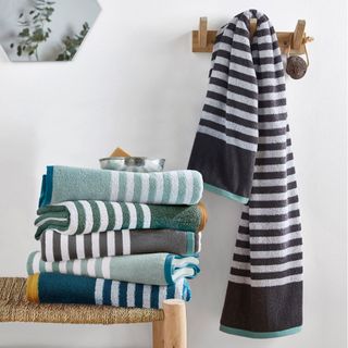 stripey bath towels folded up and hung on peg