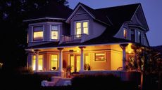 A home exterior with porch lights on at night 