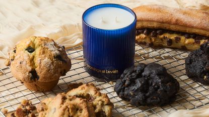 a blue candle on a cooling rack next to baked goods