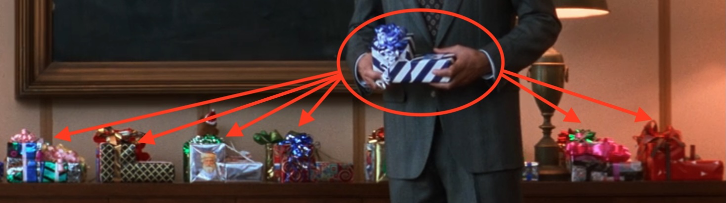 Close-up of Clark's gift for Mr. Shirley and arrows pointing to the other gifts behind him in Christmas Vacation