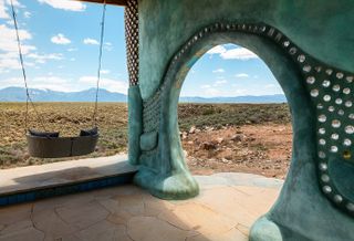 Earthship community in Taos showing colourful off grid homes nestled into the desert earth