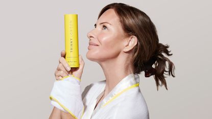 Trinny holding a bottle of her new cleanser - trinny skincare