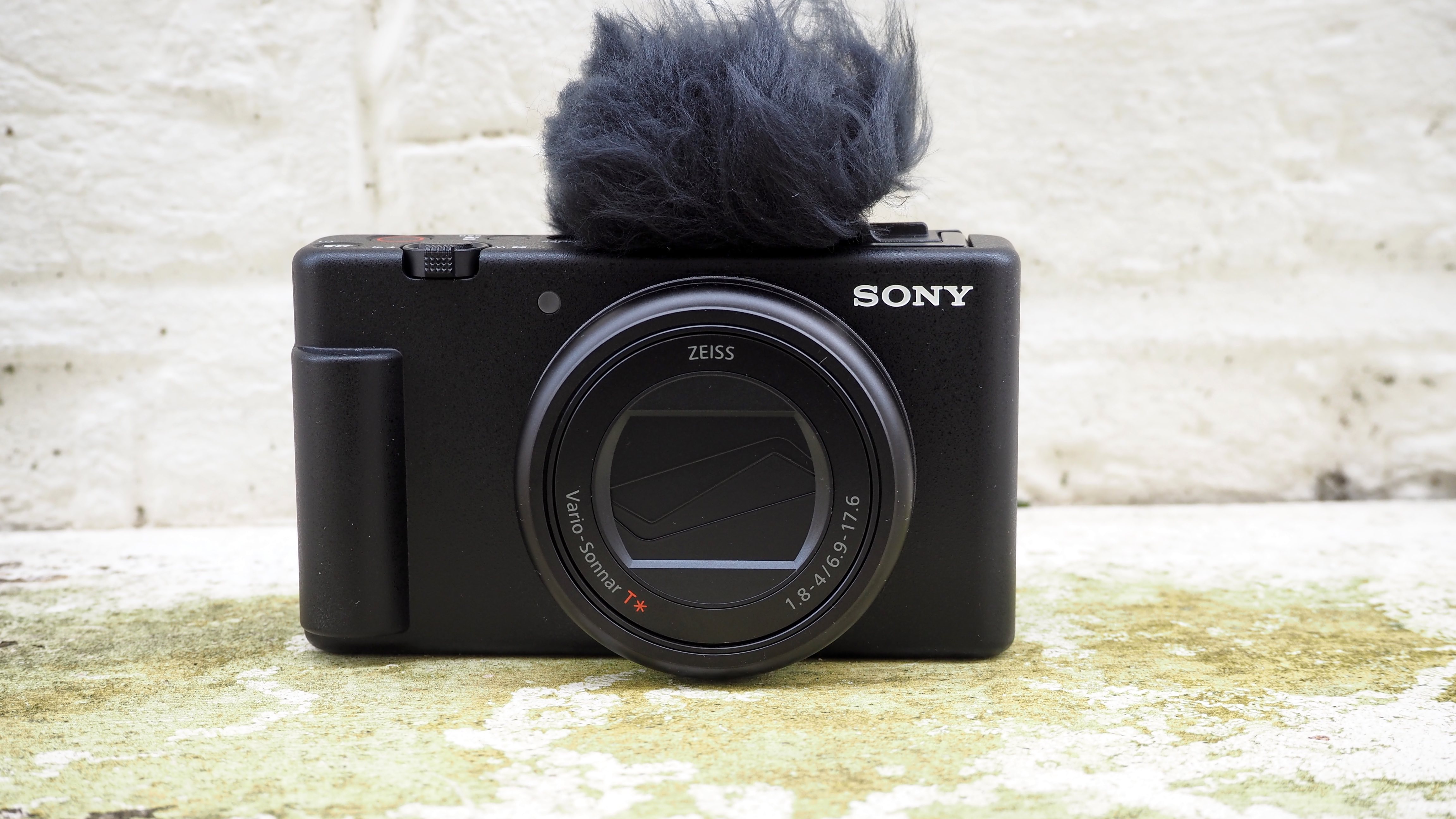 Sony Камера ZV-1 II снаружи на стене с ветровым стеклом, прикрепленным к микрофону