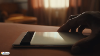 Pixel 6 face down on a desk being picked up