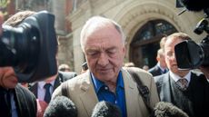Ken Livingstone is flanked by journalists in London