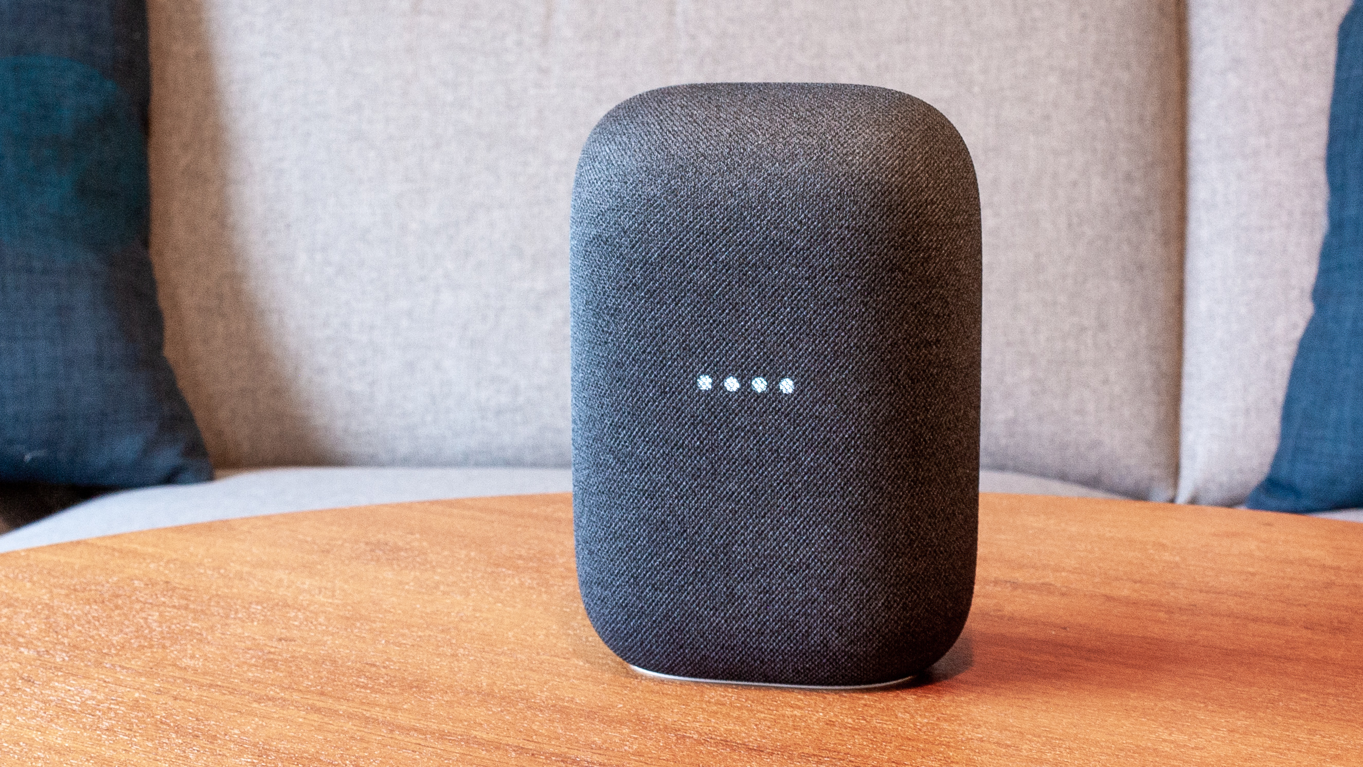 En smart-høyttaler av typen Google Nest Audio på en bordplate.