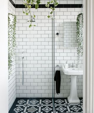 White metro wall tiles with monochrome geometric floor tiles in a shower