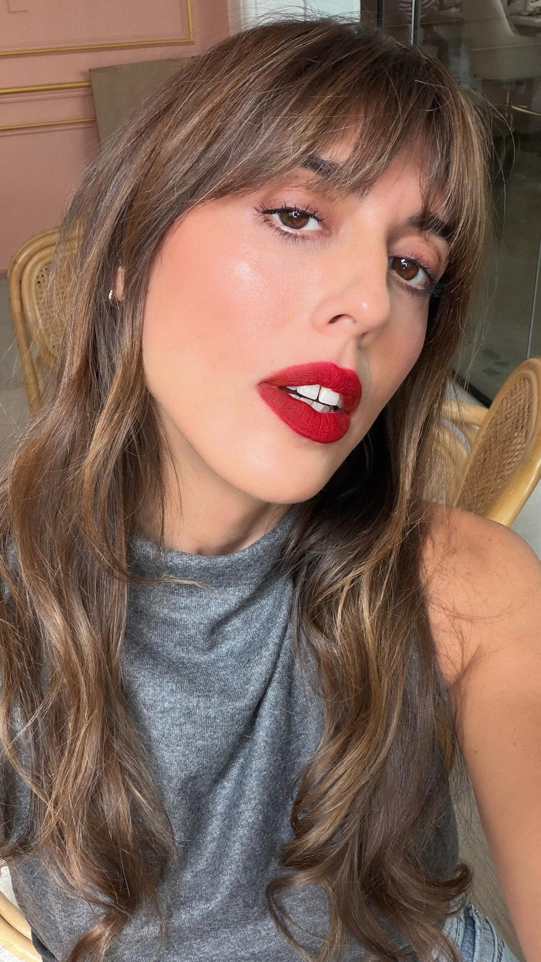 A photo of MUA Violette Serrat wearing a red lipstick