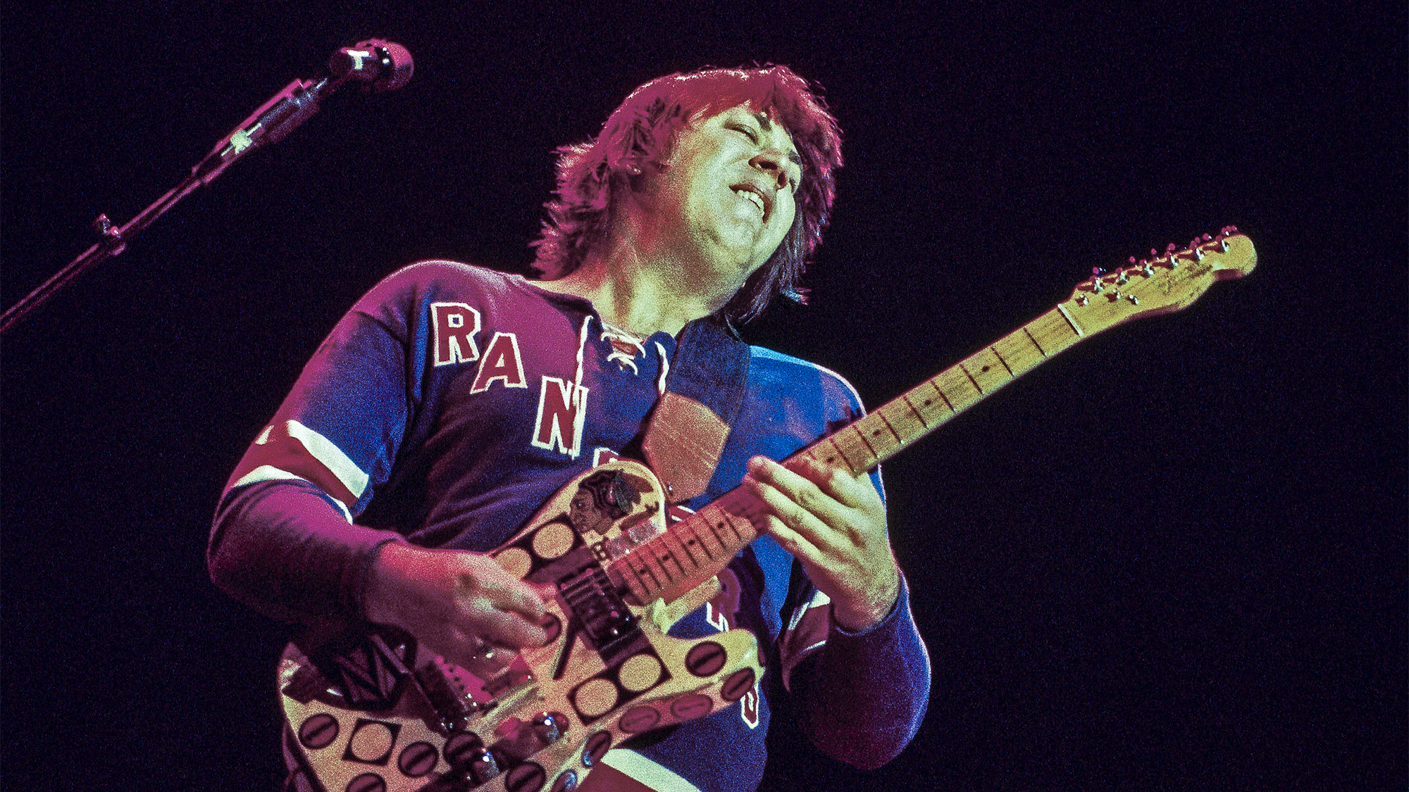 Terry Kath (1946-1978), guitarist with U.S. rock band Chicago, playing the guitar during a live concert performance at the Hammersmith Odeon in London, England, Great Britain, January 1977.