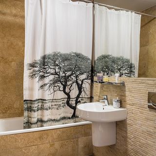 bathroom with sand coloured tiles and curtain