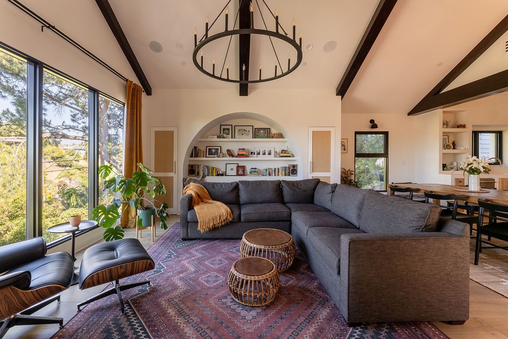 A modern living room with an arched built-in bookshelf and a large grey corner sofa