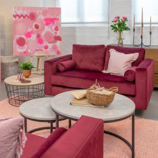 living room with red velvet sofa table and pink painting