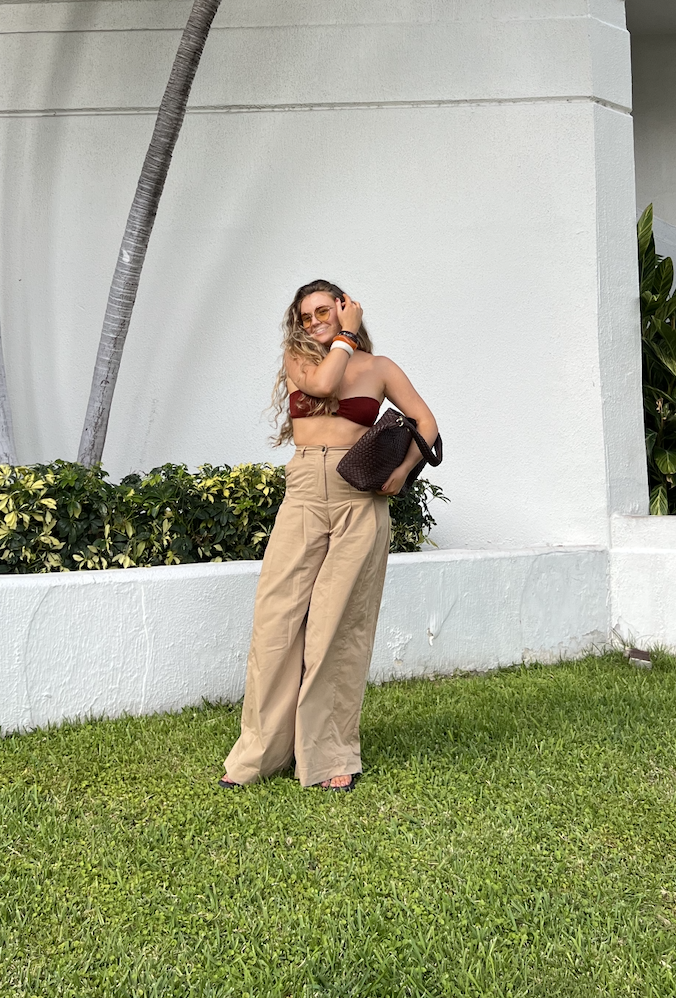 Lauren Cunningham wears brown trousers and bikini top