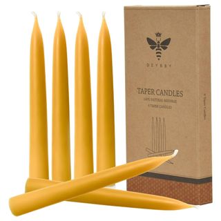 A cardboard pack of beeswax taper candles with six beeswax candles