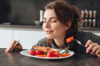 A person is smelling her food.