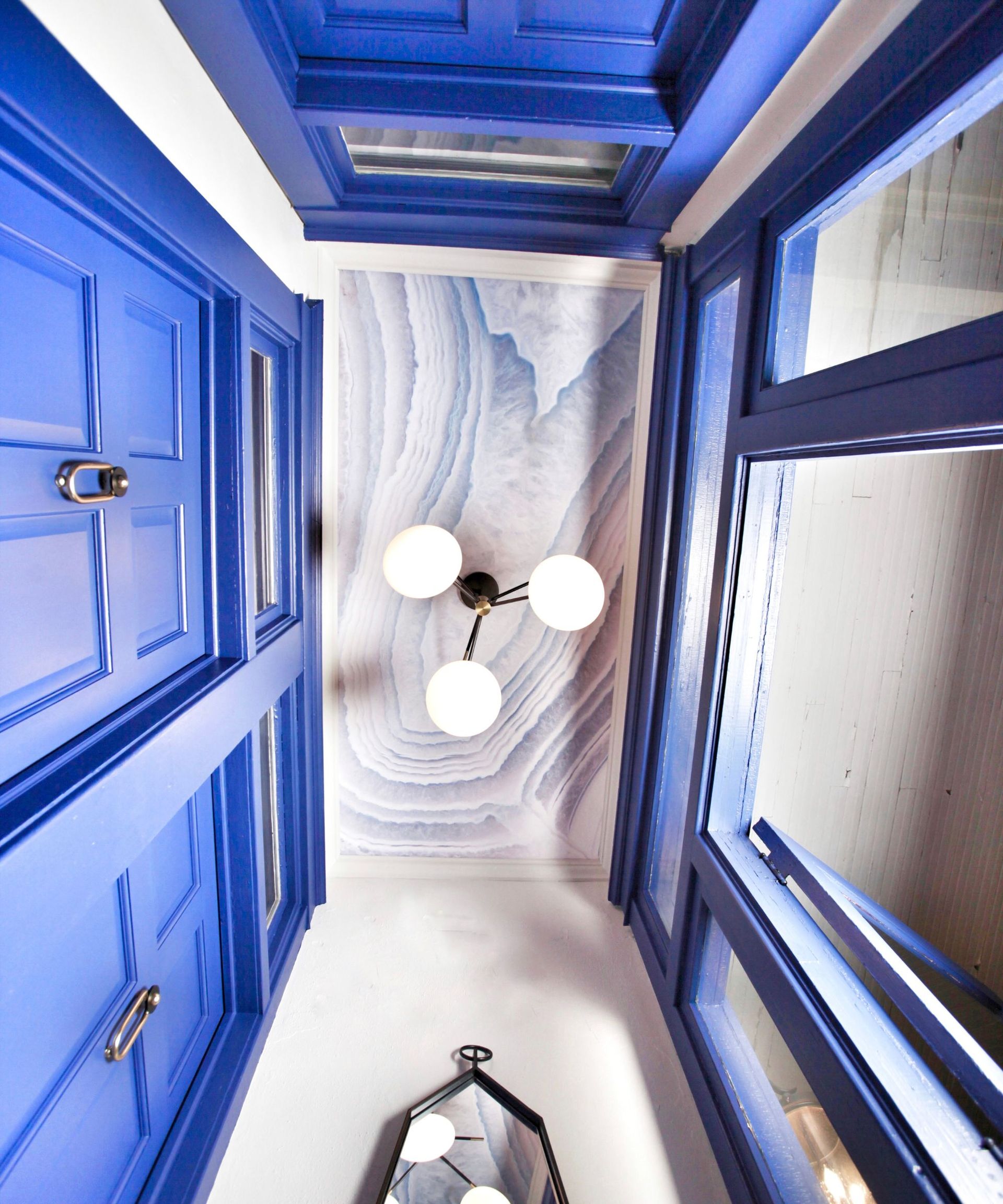 Entryway ceiling with wallpaper and cobalt blue trim