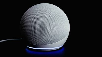 An Echo Dot sitting on a table with a black background