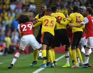 Matteo Guendouzi of Arsenal clashes with (L-R) Jose Holebas, Etienne Capoue and Adboulaye Doucoure of Watford during the Premier League match between Watford FC and Arsenal FC at Vicarage Road on September 15, 2019 in Watford, United Kingdom.