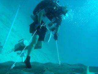 A NEEMO engineering crew diver simulates anchoring to an asteroid surface. CREDIT: NASA