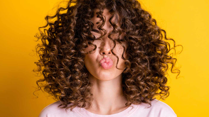 woman curly hair yellow background