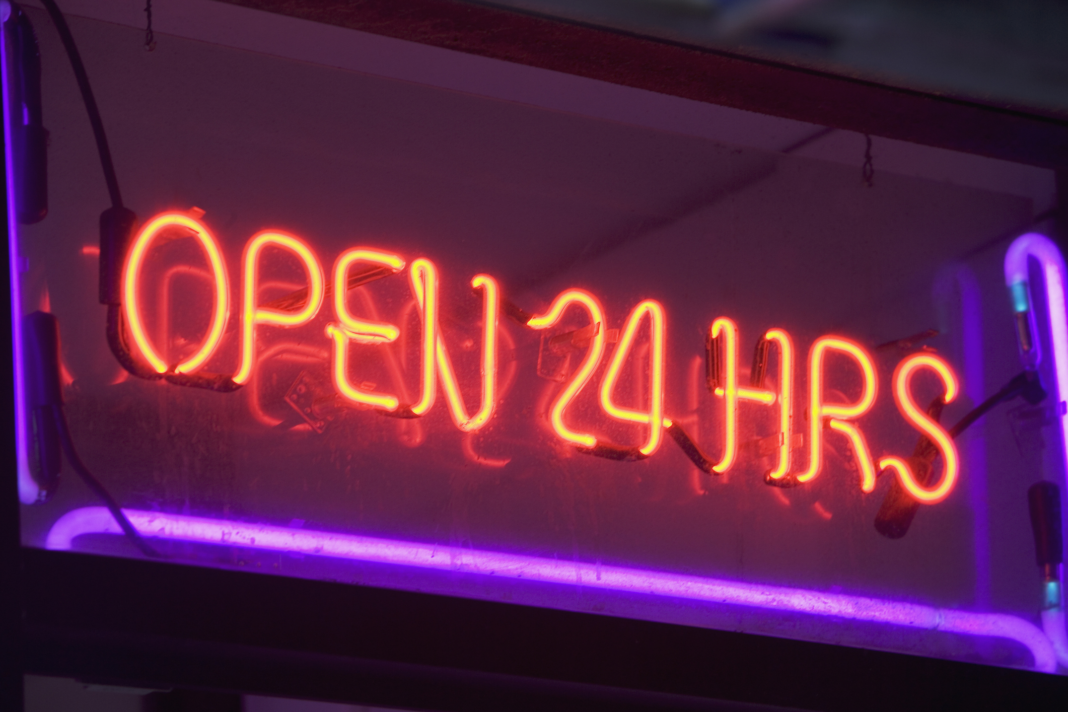 neon sign with red letters spelling out "open 24 hours"