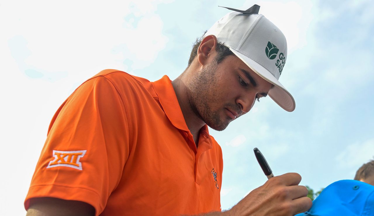 Chacarra signs autographs in an orange top