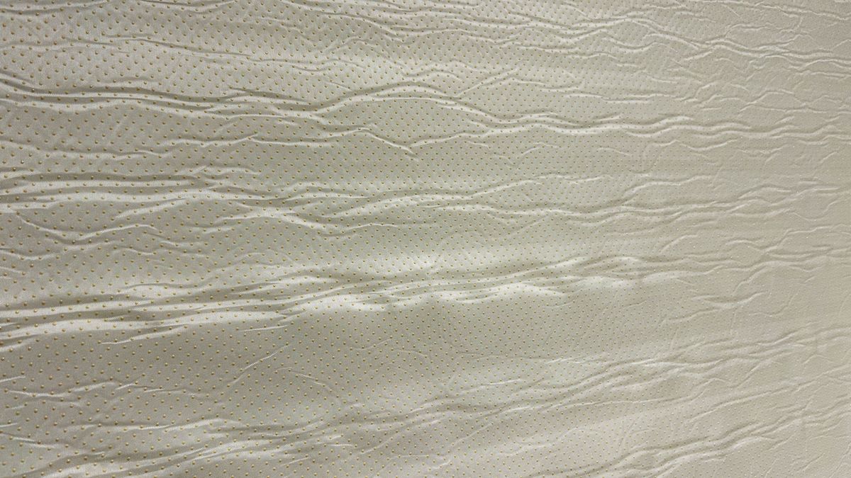 Bottom side of Valmori Hybrid II mattress depicting mattress cover and little yellow anti slip grip buttons
