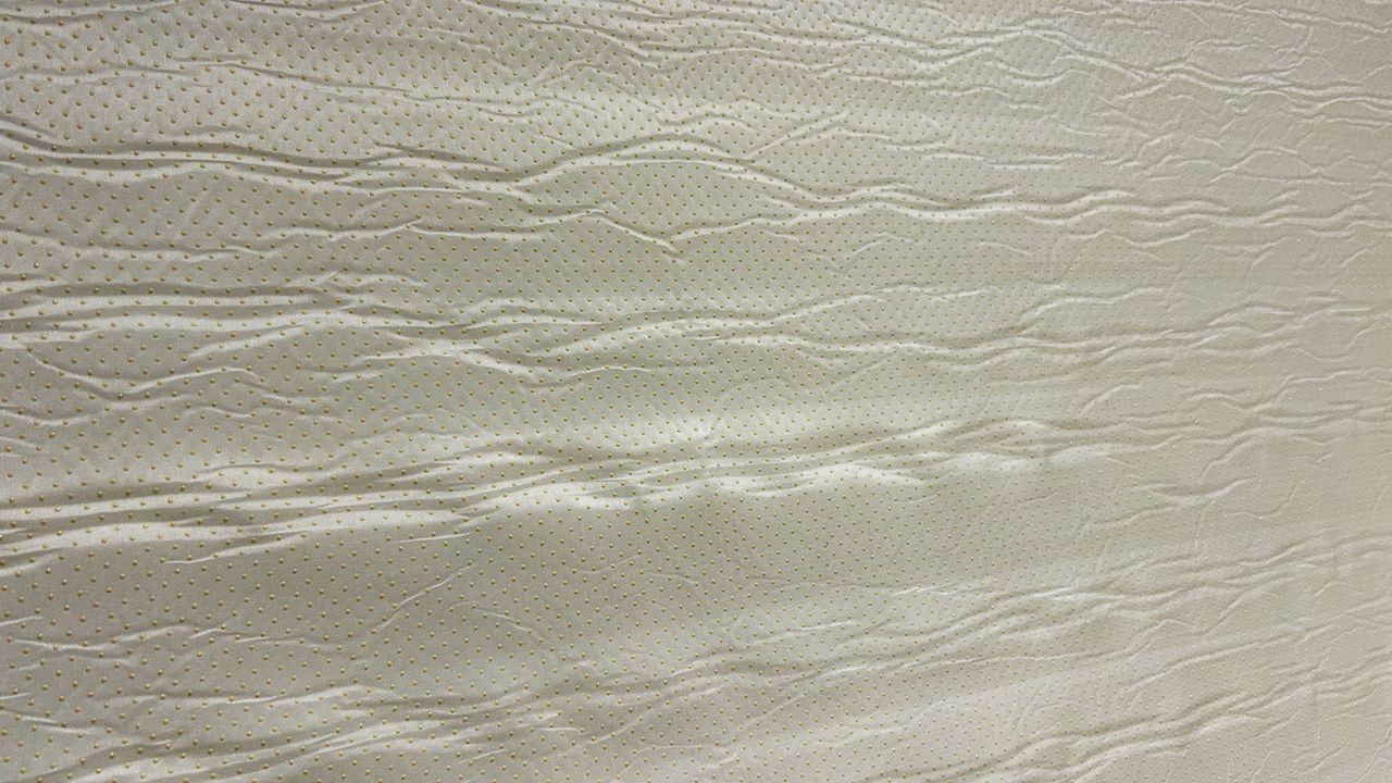 Bottom side of Valmori Hybrid II mattress depicting mattress cover and little yellow anti slip grip buttons
