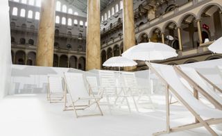 White deck chairs and umbrellas at indoor beach display in museum