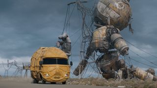 A vehicle being driven down a road with a giant dead robot on the roadside in Netflix's The Electric State movie