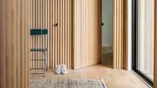 a hallway with doors hidden in fluted millwork