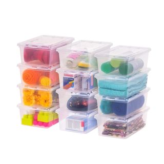 Three stacks of storage containers with colorful items inside