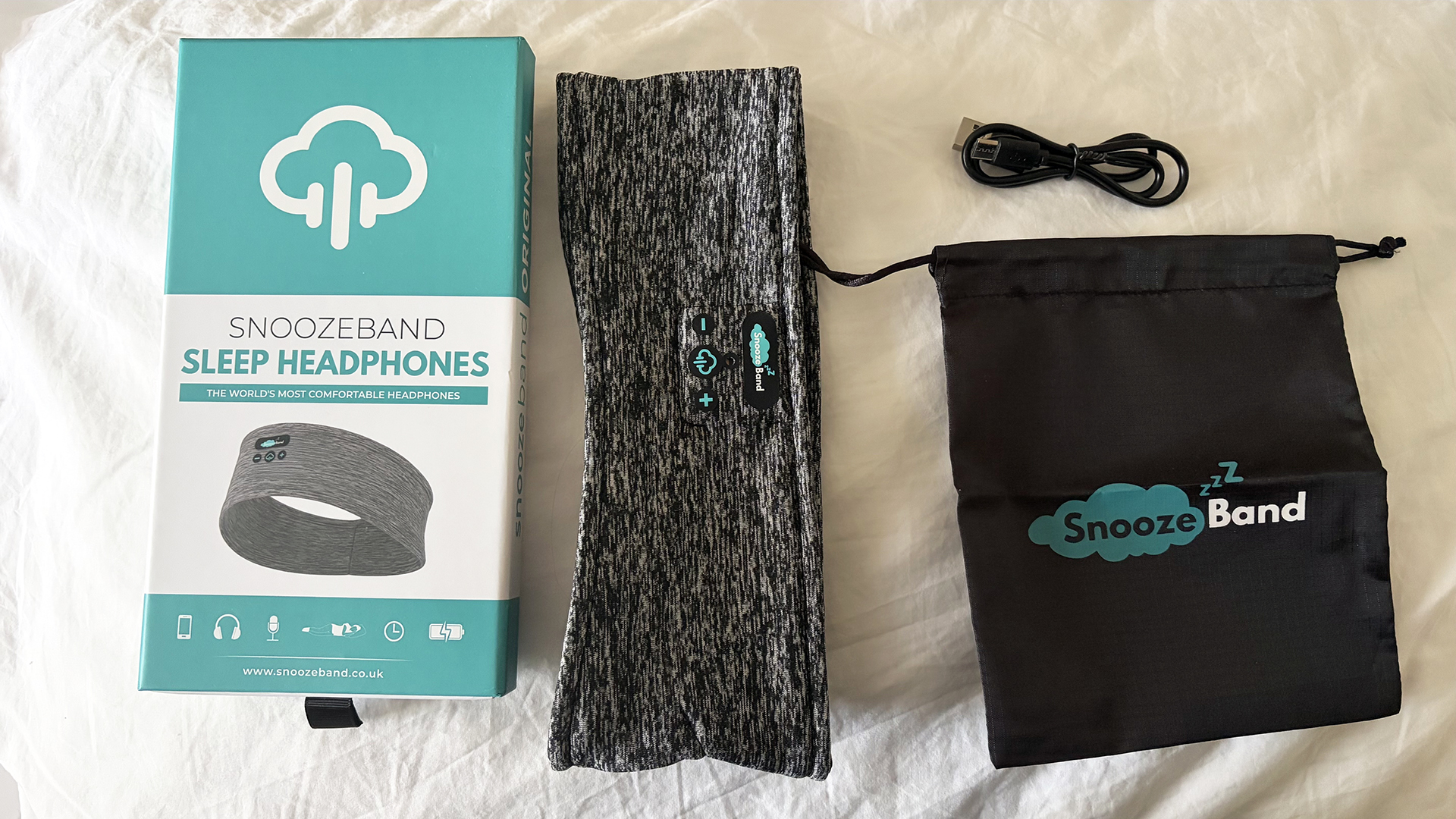 The Snoozeband Sleep Headphone box, headband, and bag, plus the charging cable