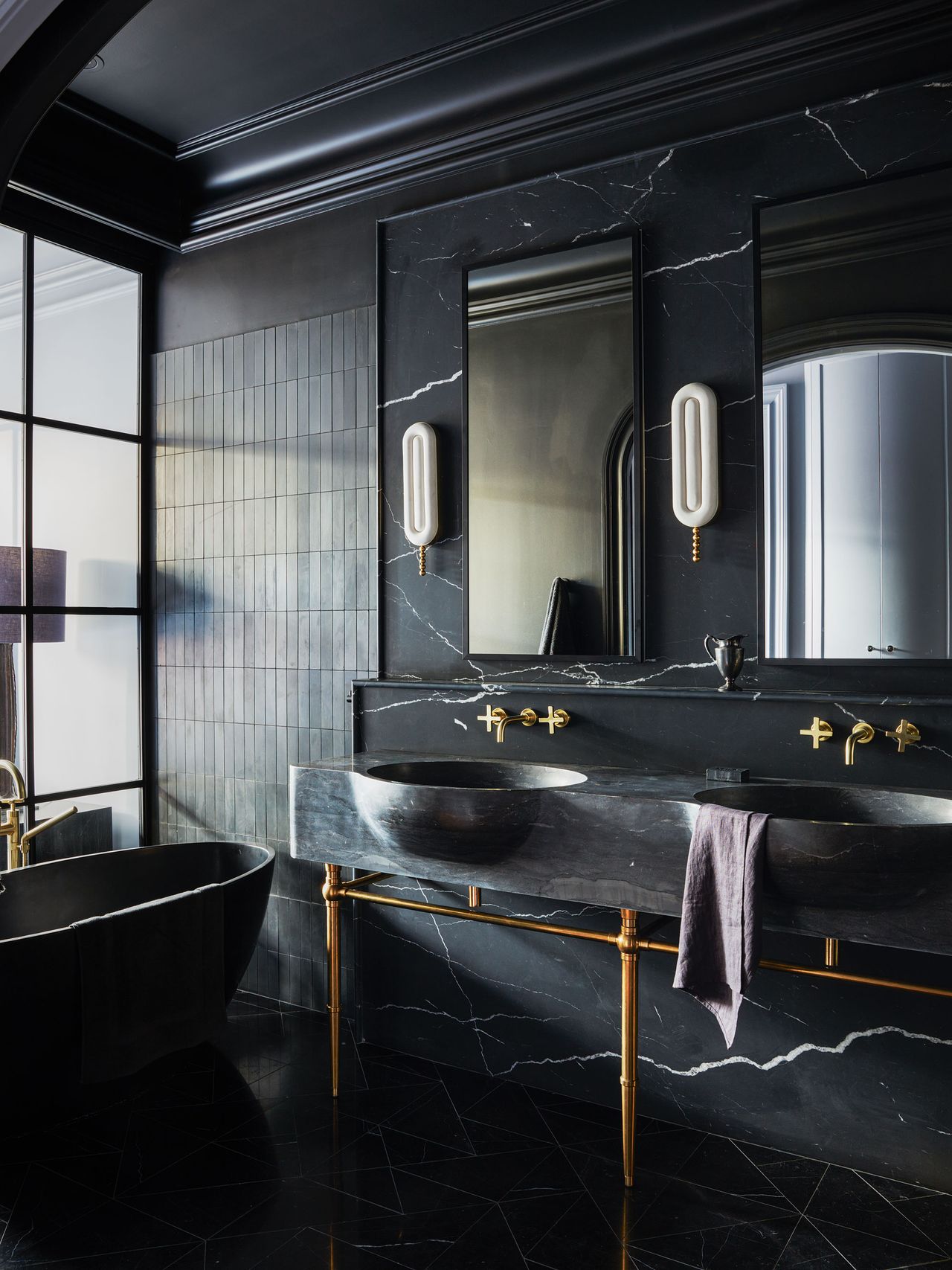 an all black bathroom with double basins and a bath