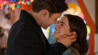 Nick Robinson holding Zoey Deutch's face as she smiles up at him in Voicemails for Isabelle. 