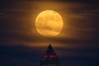 A supermoon — a full moon that occurs at lunar perigee — rises behind the Washington Monument on June 23, 2013. The New Year's Day supermoon full moon of Jan. 1, 2018 will be the biggest and brightest of the year.