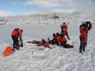 Digging the digital holographic microscopy unit into the sea ice during a field trial near Nuuk, Greenland.