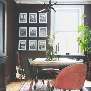 A black-painted dining room with a photography gallery wall display