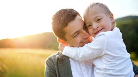 A dad holds his daughter, who has Down syndrome.