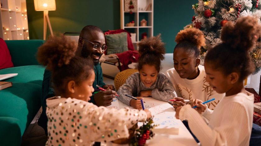 family draws on paper in christmas room