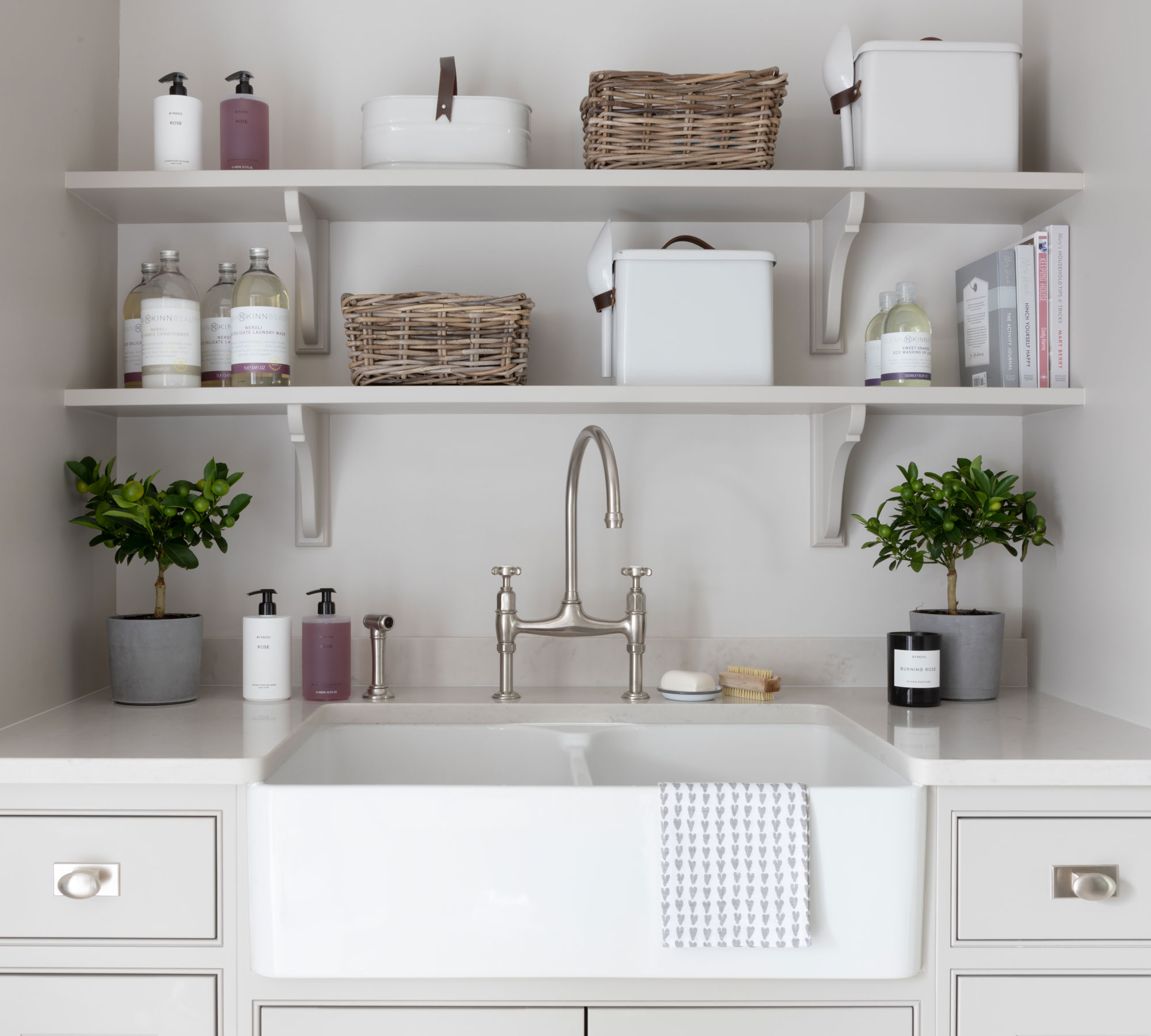 A white Belfast sink in a laundry room by KINN laundry collection, available at Humphrey Mason
