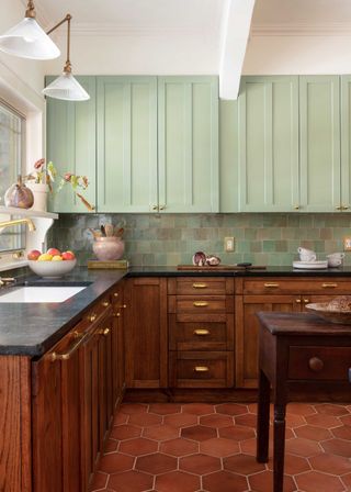a wood kitchen with green backsplash and upper cabinets