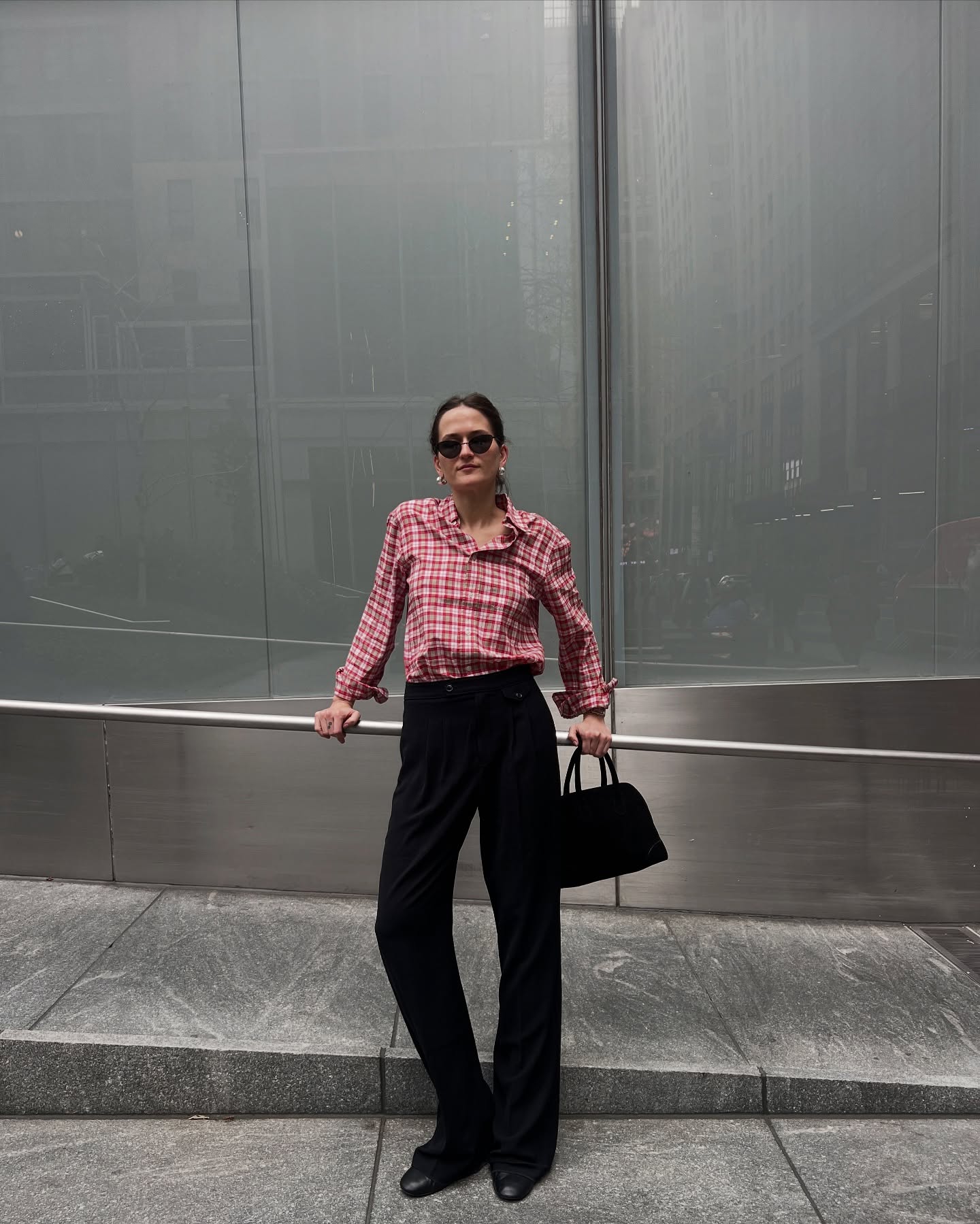 @elizagracehuber wearing a red flannel shirt and black tailored trousers.