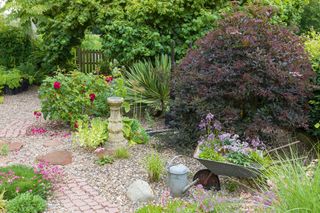 gravel garden in a cottage garden by a gate