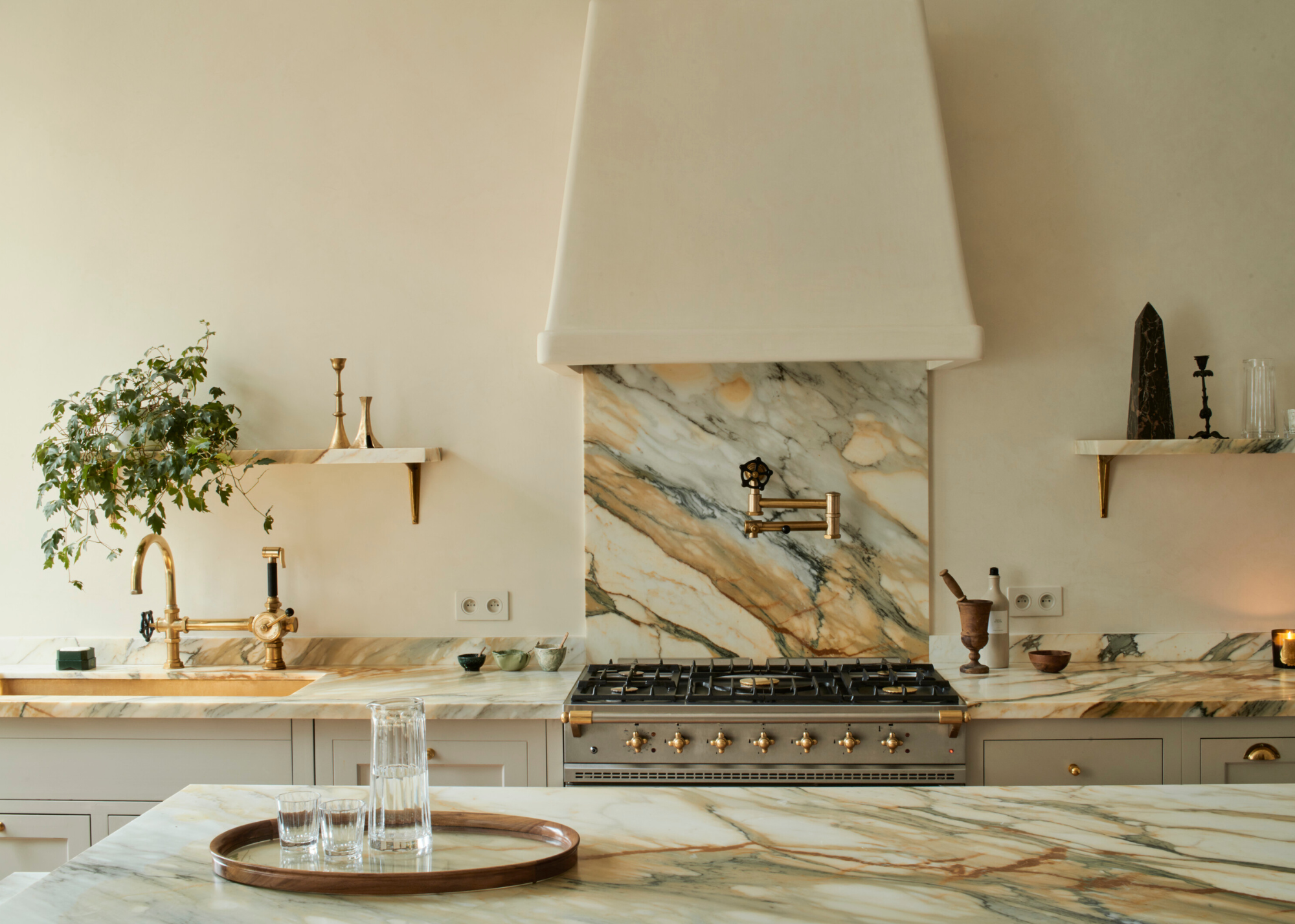 A light warm creamy kitchen with striking marble backsplash and countertop