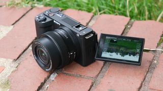 Sony ZV-E10 II digital camera with the screen extended sitting on a brick wall