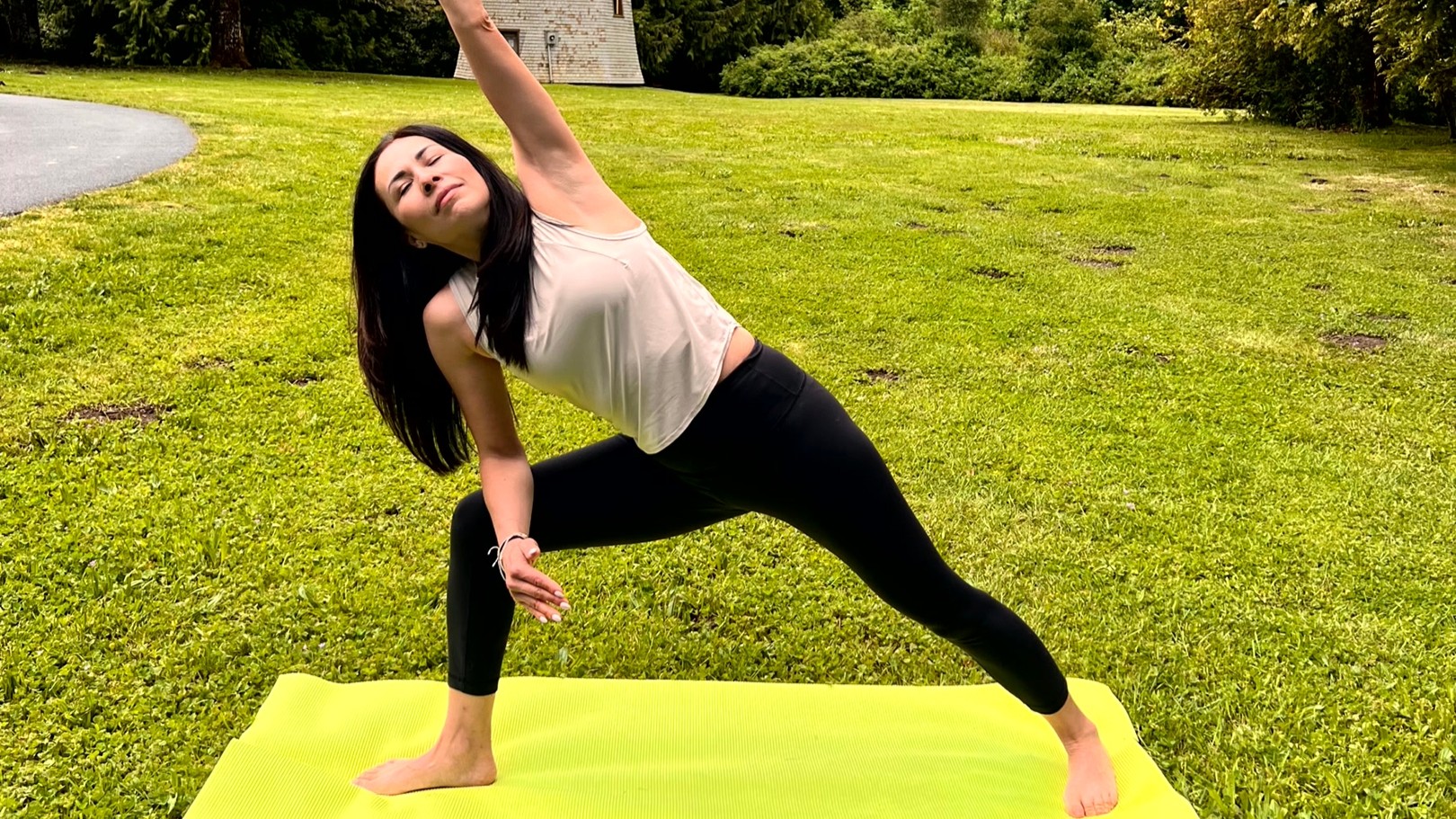 Woman in yoga pose on a mat in her garden