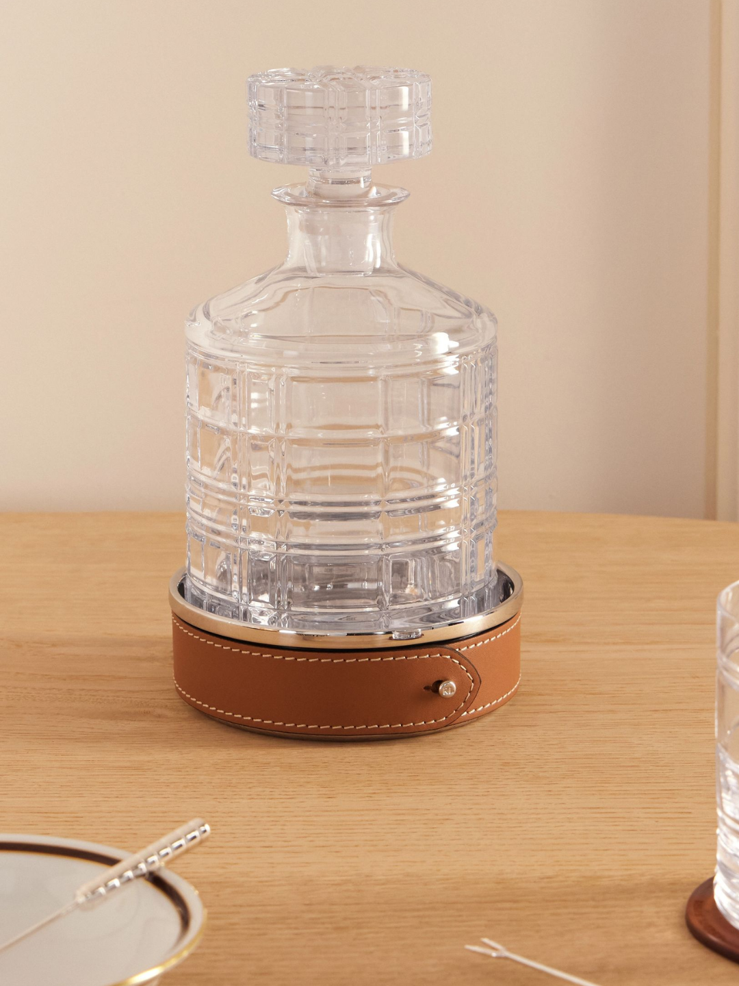 A steel wine coaster with a leather trim from Ralph Lauren Home styled with a crystal decanter