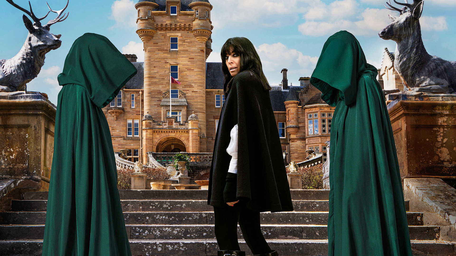 The Celebrity Traitors – Claudia Winkleman in front of Traitors castle flanked by cloaked figures