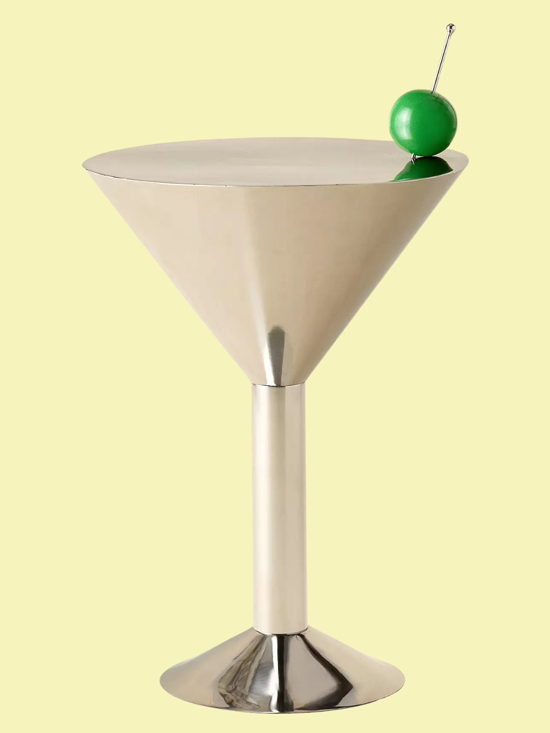 A chrome martini-shaped side table with a green olive pick